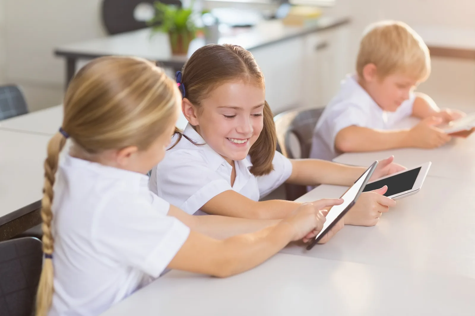 School kids using digital tablet in classroom